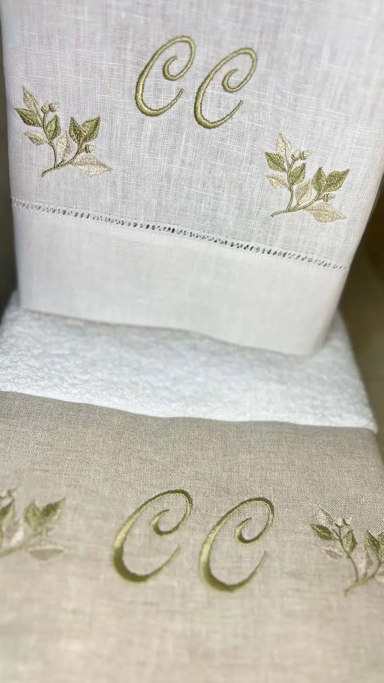 Toallas de lino con las iniciales CC y ramas bordadas en verde
