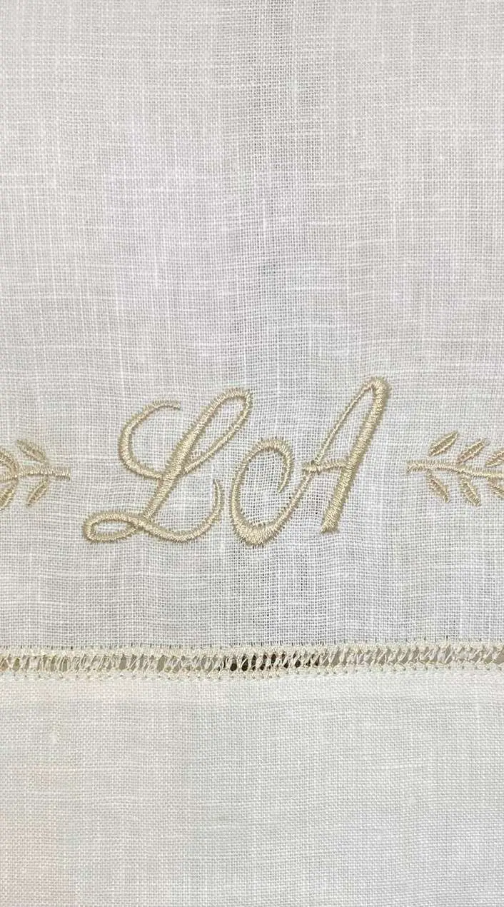 Toalla de cortesía en lino con las iniciales LCA bordadas en dorado
